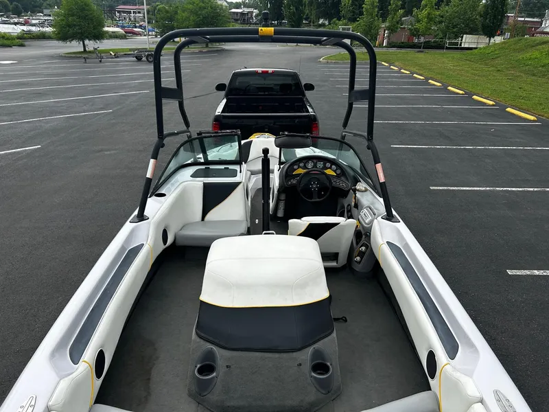 Slide: The Image of 2000 Correct Craft Air Nautique boat interior in parking lot, featuring seating and dashboard. - 7