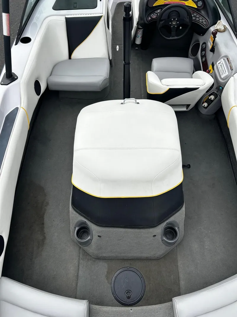 Slide: The Image of 2000 Correct Craft Air Nautique boat interior with white and black seating, steering console, and carpeted floor. - 8