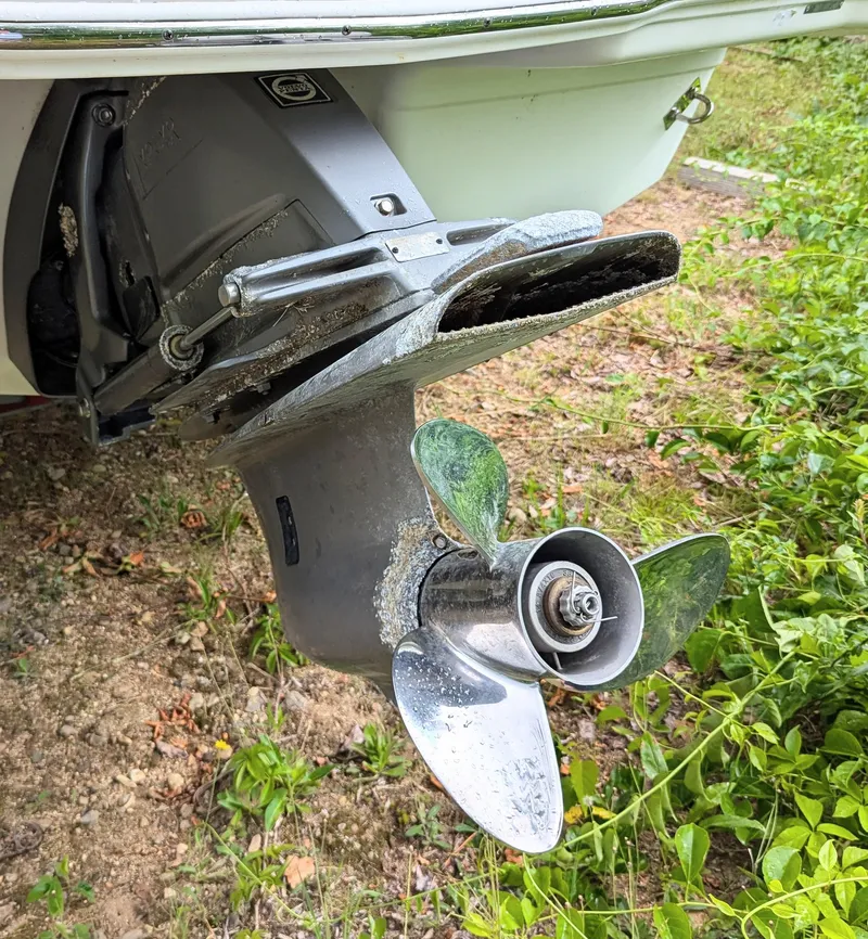 Slide: The Image of 2016 Chaparral 216 SSi boat propeller with visible wear, surrounded by grass. - 11