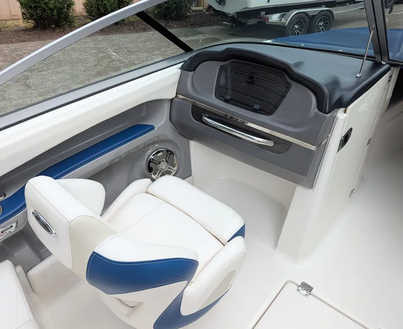 Slide: The Image of 2016 Chaparral 216 SSi boat interior with white and blue seating and dashboard. - 4