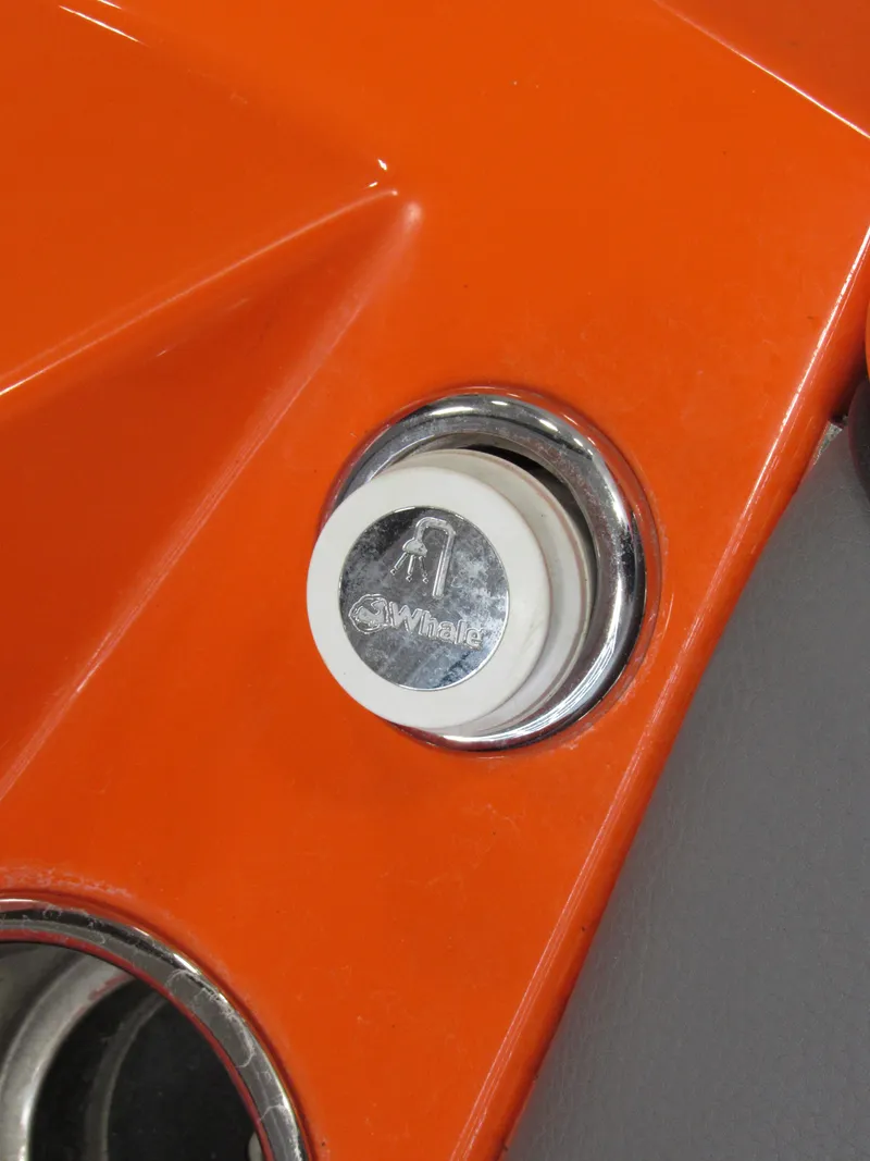 Slide: The Image of Close-up of a 2021 Malibu Wakesetter 22 LSV boat's orange exterior with a Whale fitting. - 13