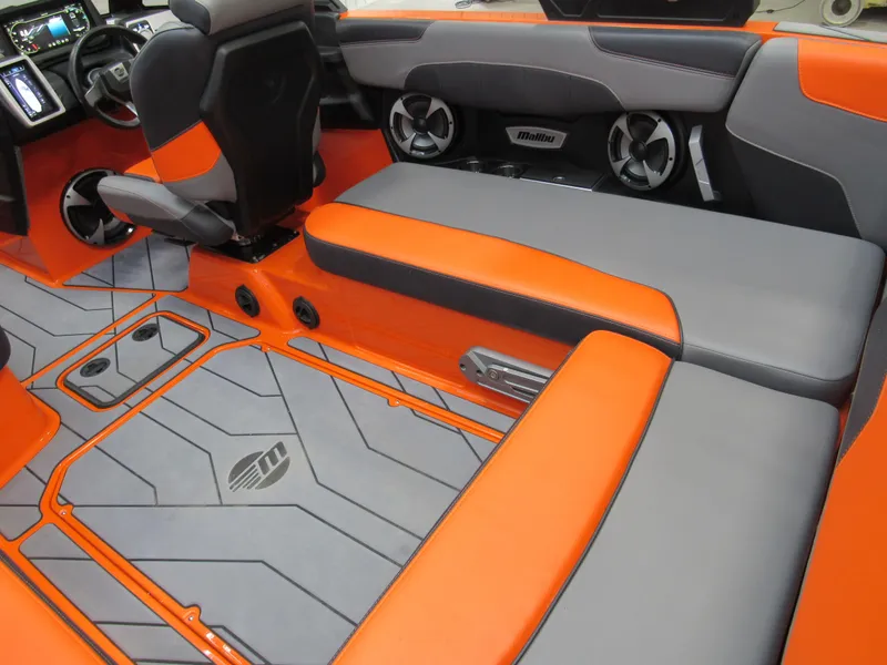 Slide: The Image of 2021 Malibu Wakesetter 22 LSV interior with orange and gray seating and advanced dashboard. - 4
