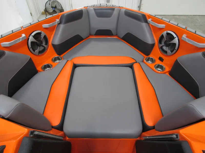 Slide: The Image of 2021 Malibu Wakesetter 22 LSV interior with orange and gray seating, cup holders, and speakers. - 9