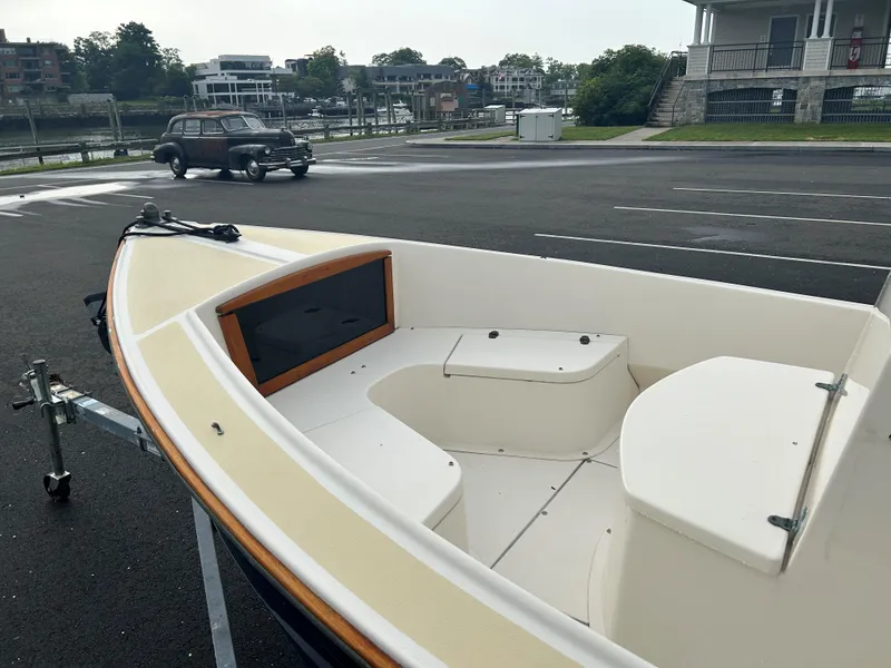 Slide: The Image of 2014 Nantucket Boat Works 17 Skiff on trailer in parking lot near vintage car. - 7