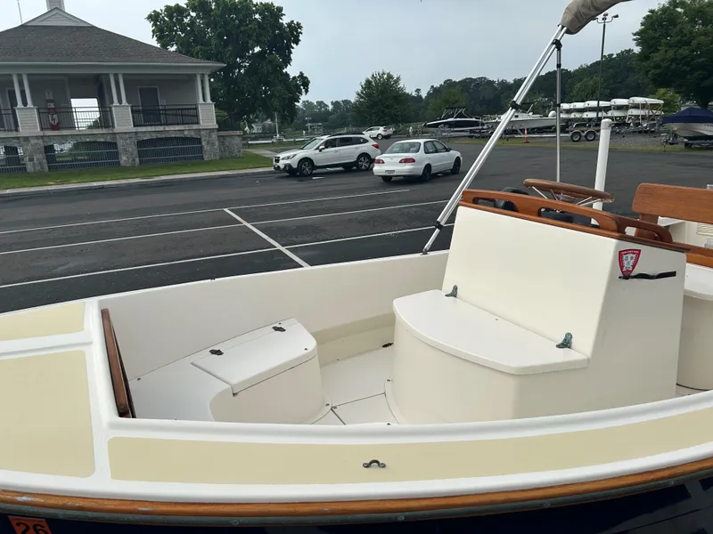 Slide: The Image of 2014 Nantucket Boat Works 17 Skiff in parking lot, near a pavilion and parked cars. - 8