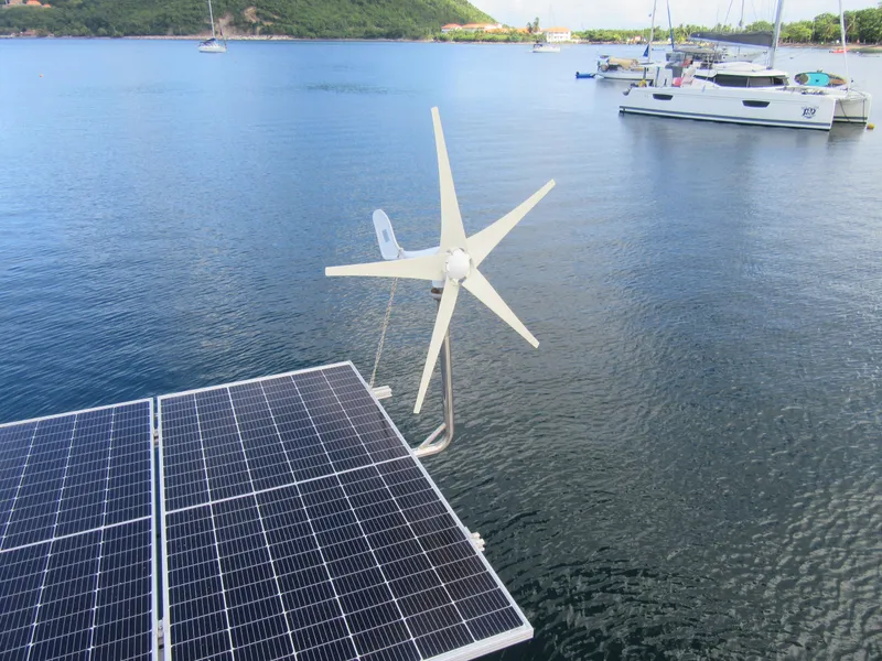 Slide: The Image of Solar panels and wind turbine on a Bali 4.1 catamaran, anchored in a serene bay. - 33