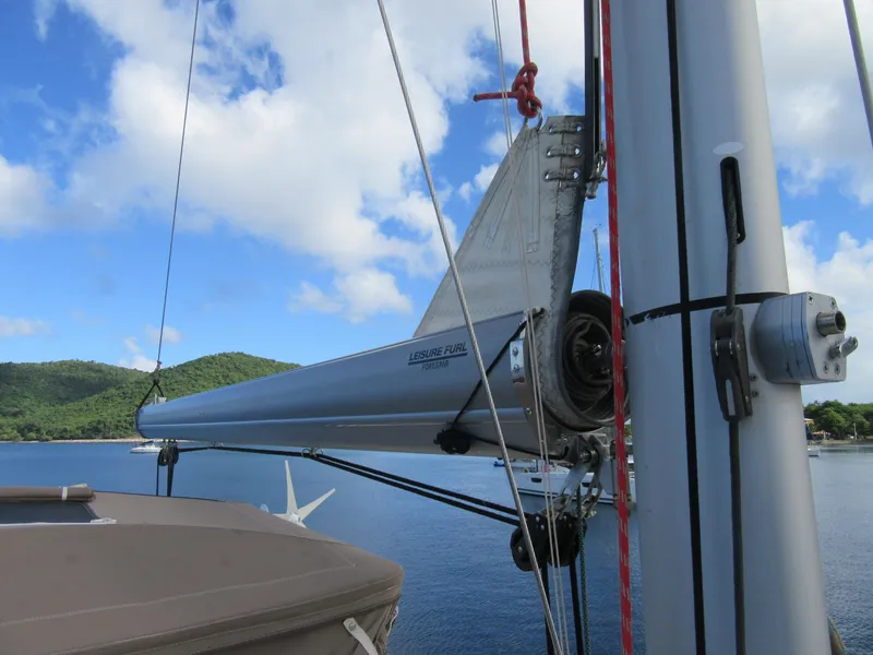 Slide: The Image of Sailboat mast with furling system, Bali 4.1 model, anchored near lush green hills. - 38