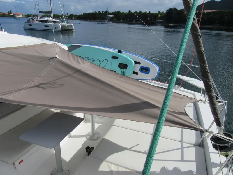 Slide: The Image of Catamaran Bali 4.1 with sunshade and paddleboard on calm water, 2020 model. - 47