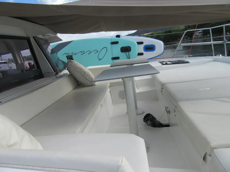 Slide: The Image of Luxurious Bali 4.1 catamaran deck with seating, table, and paddleboard, 2020 model. - 49