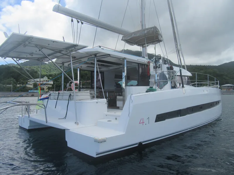 Slide: The Image of 2020 Bali 4.1 catamaran anchored near lush coastline under cloudy sky. - 9