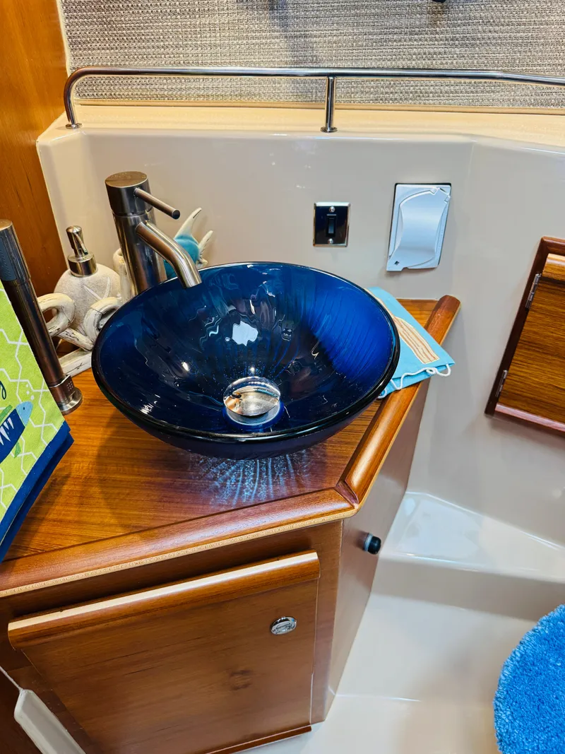 Slide: The Image of Luxurious bathroom sink in 2018 Ranger Tugs R-27 boat, featuring a stylish blue glass basin. - 15