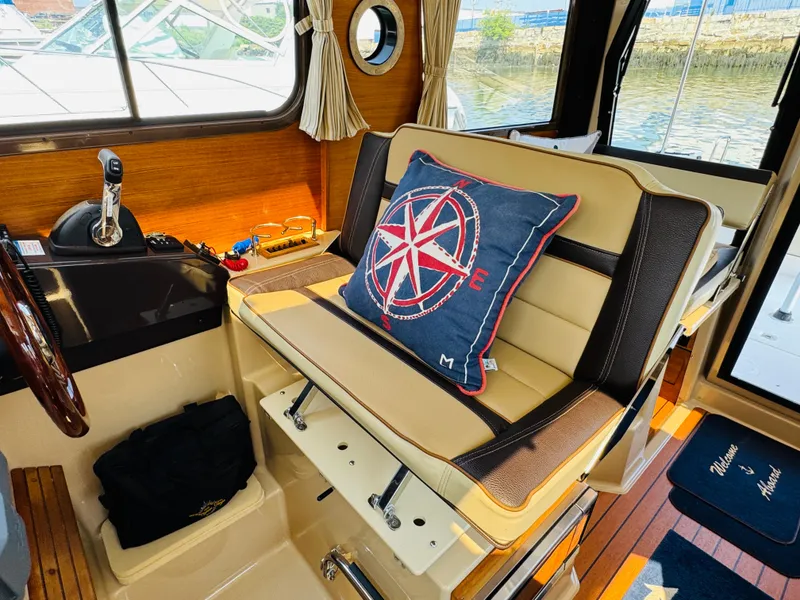 Slide: The Image of Interior of 2018 Ranger Tugs R-27 boat with nautical-themed decor and steering controls. - 22