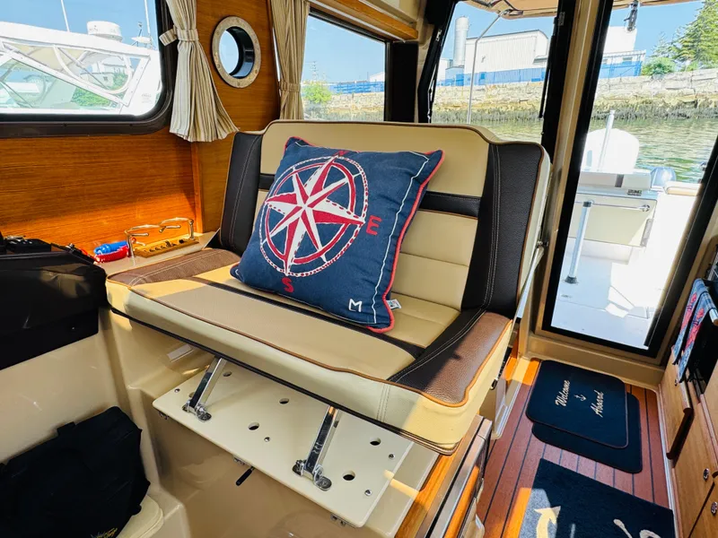 Slide: The Image of Interior of 2018 Ranger Tugs R-27 with nautical-themed cushion and wooden accents. - 23