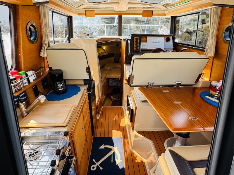 Slide: The Image of Interior of 2018 Ranger Tugs R-27 boat with wood finishes and compact kitchen area. - 3