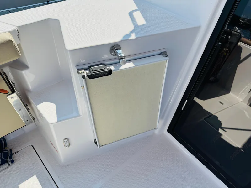 Slide: The Image of 2018 Ranger Tugs R-27 boat interior, featuring a compact, built-in refrigerator and seating area. - 31