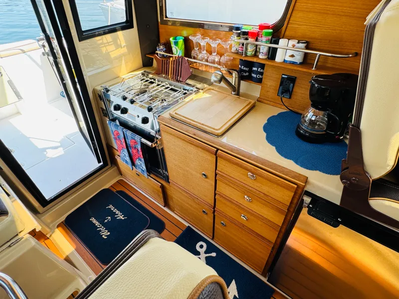 Slide: The Image of 2018 Ranger Tugs R-27 boat kitchen with stove, sink, and coffee maker. - 4