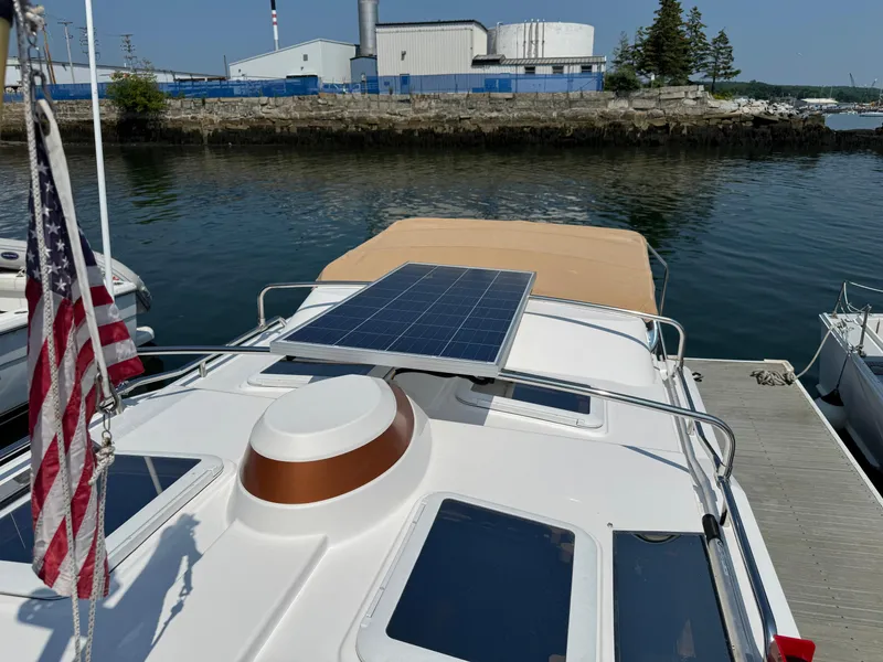 Slide: The Image of 2018 Ranger Tugs R-27 with solar panel, docked near industrial waterfront. - 43