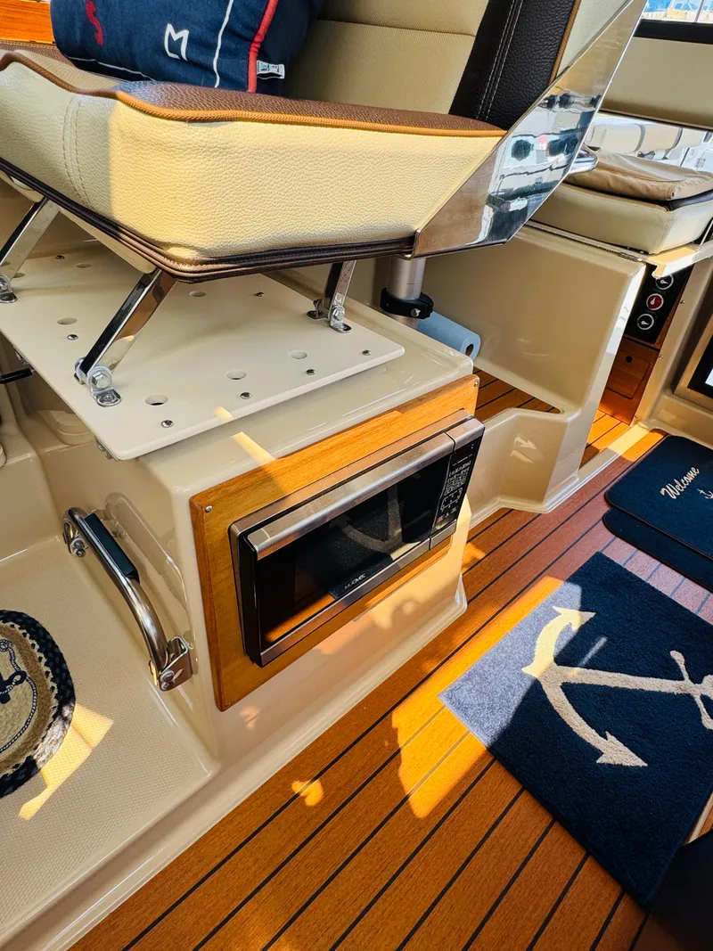 Slide: The Image of Interior of 2018 Ranger Tugs R-27 boat with microwave and wooden flooring. - 8