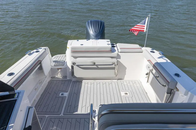 Slide: The Image of Manufacturer Provided Image: 2025 Solara S-250 DC boat deck with seating, American flag, and outboard motor on water. - 10