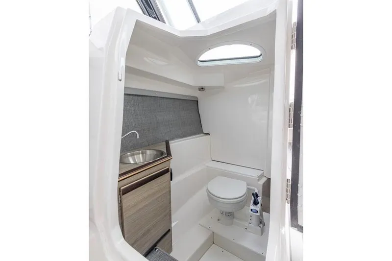 Slide: The Image of Manufacturer Provided Image: 2025 Solara S-250 DC boat interior with compact bathroom, featuring a toilet and sink. - 7
