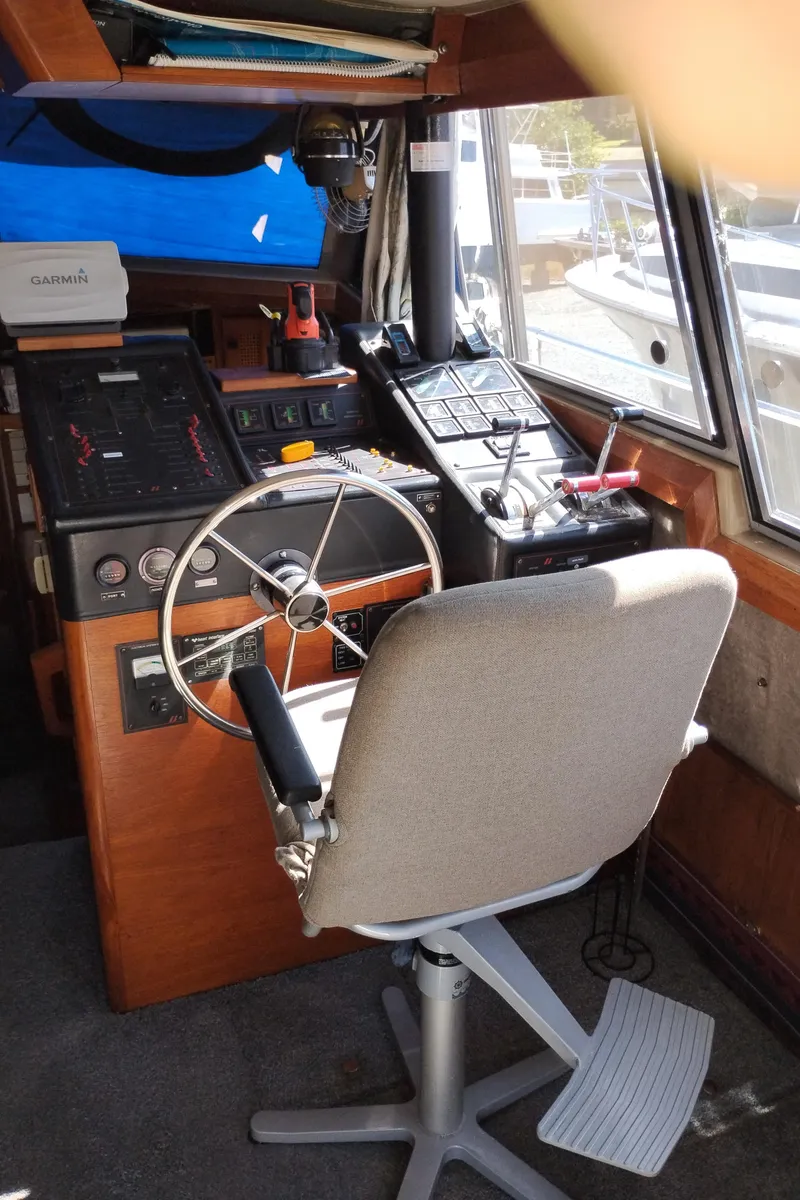 Slide: The Image of 1986 Bayliner 3870 Motoryacht helm with steering wheel, navigation equipment, and captain's chair. - 10