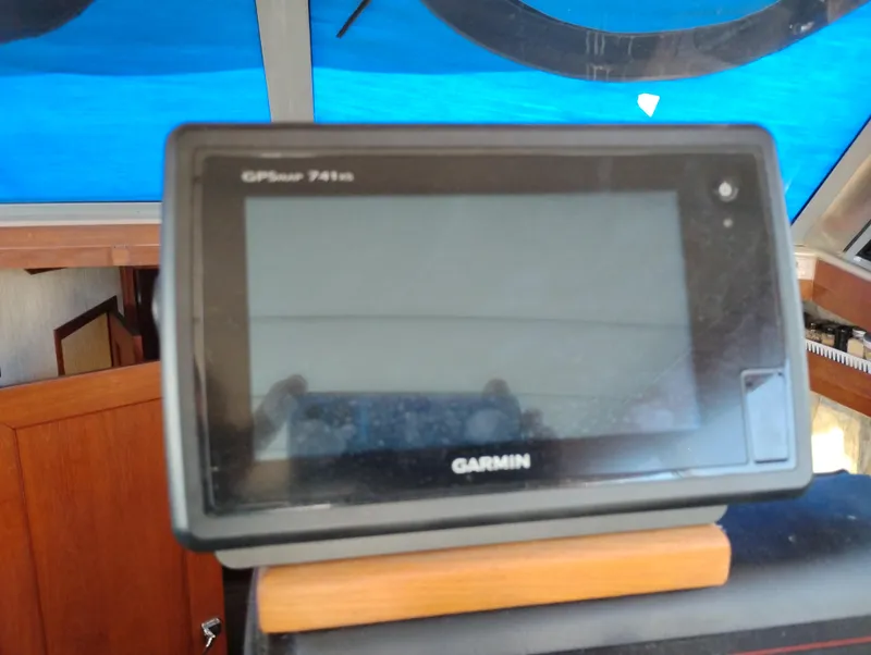 Slide: The Image of Garmin GPS device on 1986 Bayliner 3870 Motoryacht dashboard, blue background. - 11