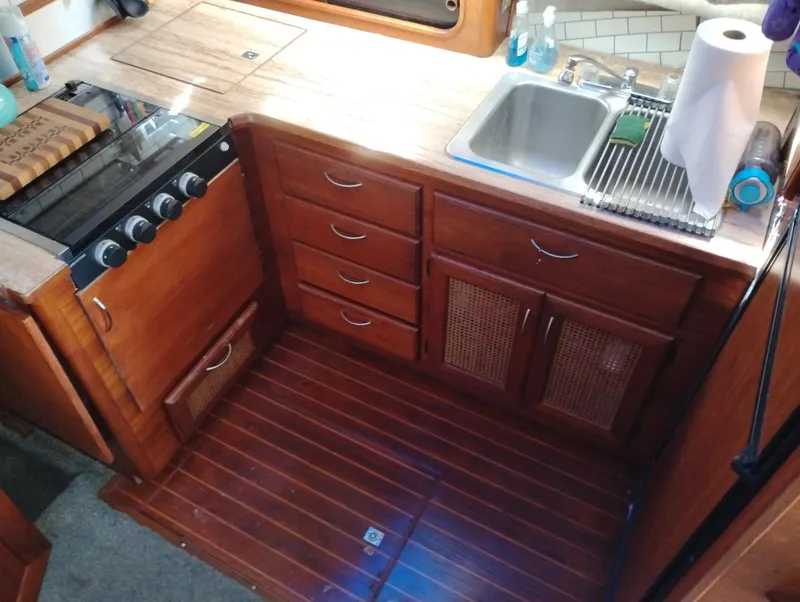 Slide: The Image of 1986 Bayliner 3870 Motoryacht kitchen with wooden cabinets, stove, and sink. - 15