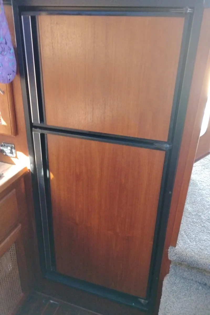 Slide: The Image of 1986 Bayliner 3870 Motoryacht interior with wooden paneling and black trim. - 17