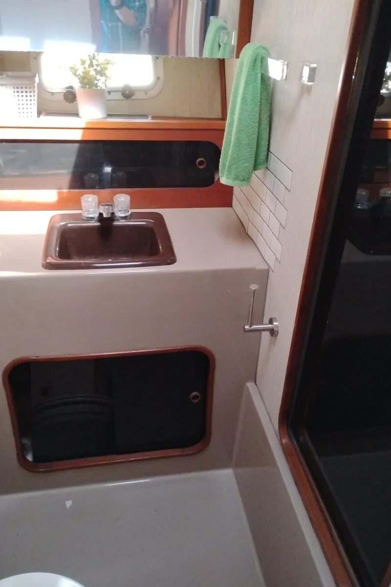 Slide: The Image of 1986 Bayliner 3870 Motoryacht bathroom with sink, mirror, and green towel. - 18