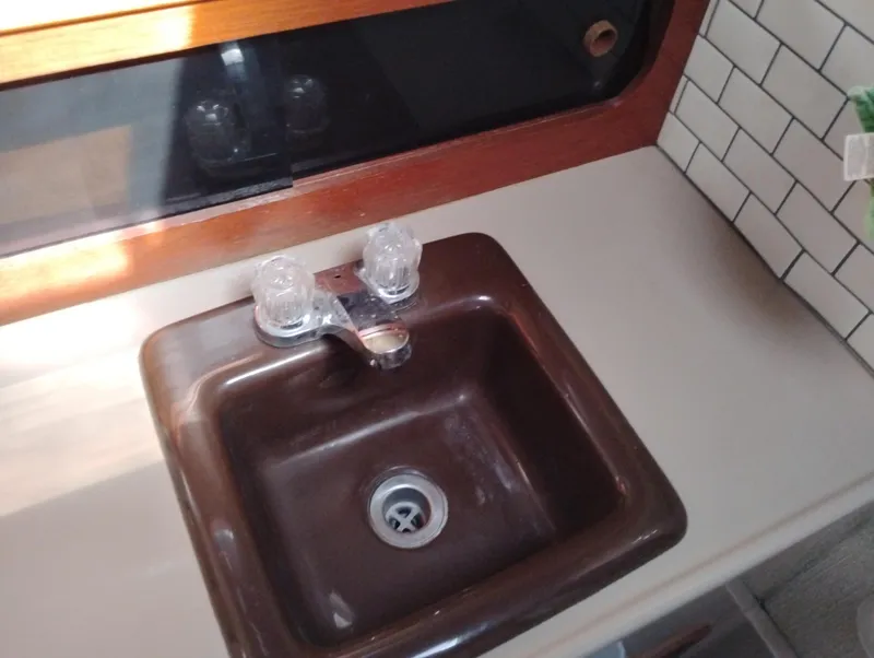 Slide: The Image of Brown sink with dual faucets in 1986 Bayliner 3870 Motoryacht kitchen area. - 19