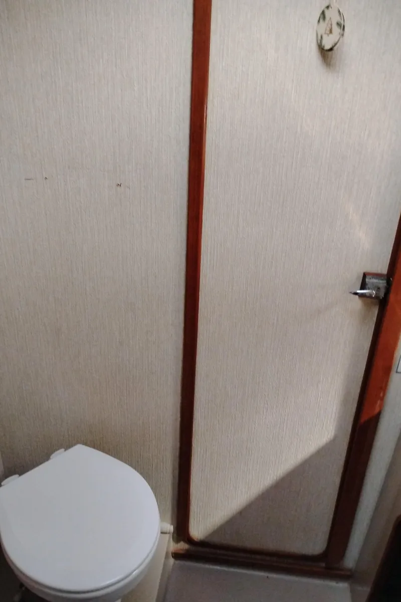 Slide: The Image of 1986 Bayliner 3870 Motoryacht bathroom with toilet and wooden door. - 20
