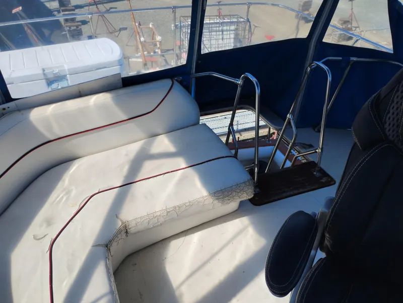 Slide: The Image of 1986 Bayliner 3870 Motoryacht interior with white seating and metal railings. - 4
