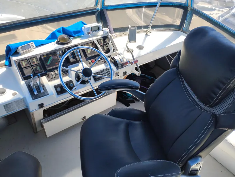 Slide: The Image of 1986 Bayliner 3870 Motoryacht helm with steering wheel, controls, and captain's chair. - 5