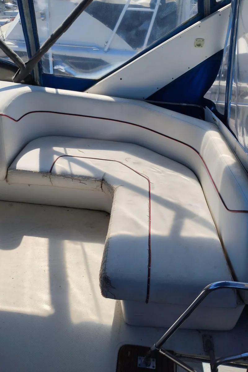 Slide: The Image of 1986 Bayliner 3870 Motoryacht interior seating with white upholstery and red trim. - 7