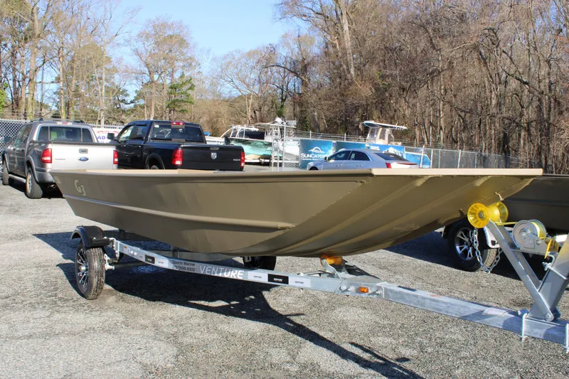 The Image of 2025 G3 Gator Tough 1652 VBW boat on trailer in parking lot. - 0