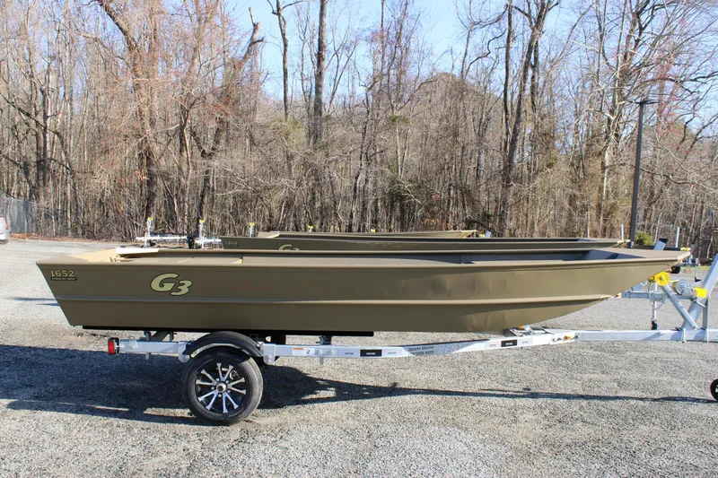 Slide: The Image of 2025 G3 Gator Tough 1652 VBW boat on trailer, parked outdoors. - 8