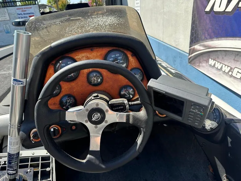 Slide: The Image of Dashboard of a 1999 Fisher 21 FX DC boat with steering wheel and gauges. - 13