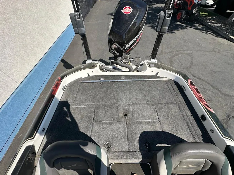 Slide: The Image of 1999 Fisher 21 FX DC boat deck with Mercury outboard motor, parked on pavement. - 17