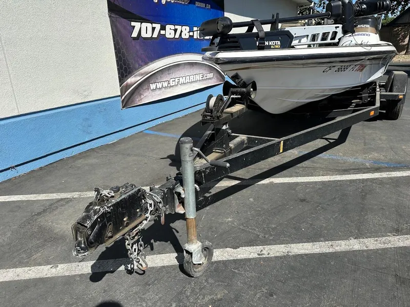 Slide: The Image of 1999 Fisher 21 FX DC boat on trailer, parked outdoors near a blue and white building. - 5
