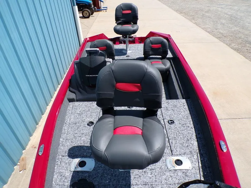 Slide: The Image of 2025 Tracker Pro Team 175 TF® boat with red and black seating, docked near a blue building. - 12