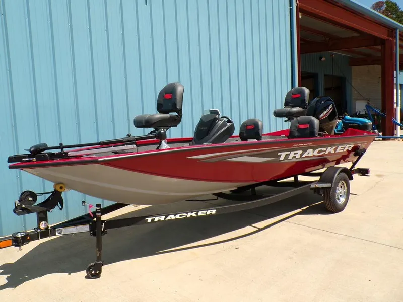 Slide: The Image of 2025 Tracker Pro Team 175 TF® fishing boat on trailer, parked outside a blue building. - 2