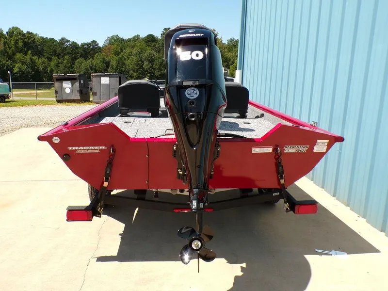 Slide: The Image of 2025 Tracker Pro Team 175 TF® boat, red, with a 50 HP outboard motor, parked outdoors. - 4