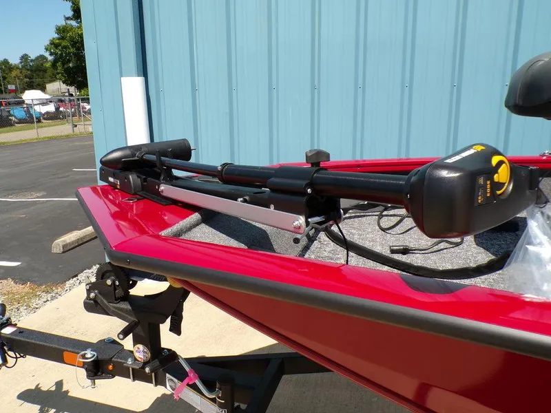 Slide: The Image of 2025 Tracker Pro Team 175 TF® boat with trolling motor, red hull, parked near blue building. - 9