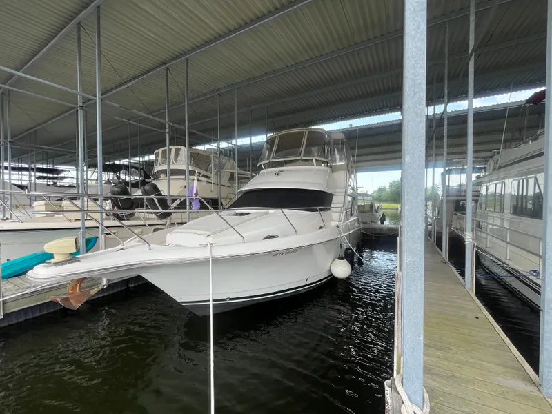 The Image of 1999 Silverton 392 Aft Cabin yacht docked in a covered marina. - 1