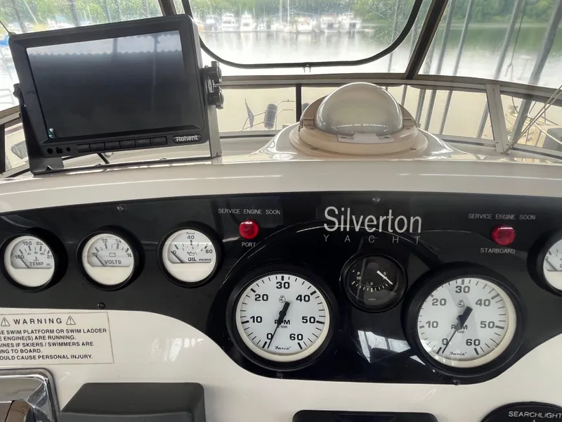 Slide: The Image of Control panel of a 1999 Silverton 392 Aft Cabin yacht with gauges and navigation equipment. - 15