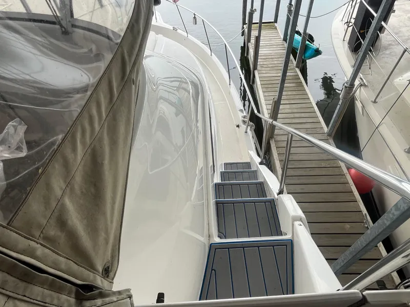 Slide: The Image of 1999 Silverton 392 Aft Cabin yacht docked, showing deck and walkway details. - 17