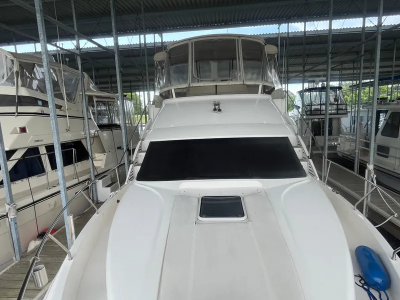 Slide: The Image of 1999 Silverton 392 Aft Cabin yacht docked in a covered marina. - 20