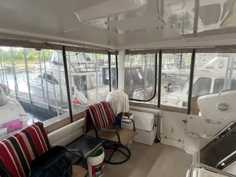 Slide: The Image of 1999 Silverton 392 Aft Cabin interior with marina view, featuring seating and nautical decor. - 21