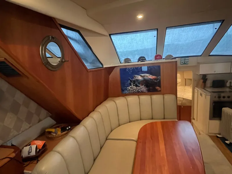 Slide: The Image of 1999 Silverton 392 Aft Cabin interior with wood paneling, dining area, and kitchen. - 25