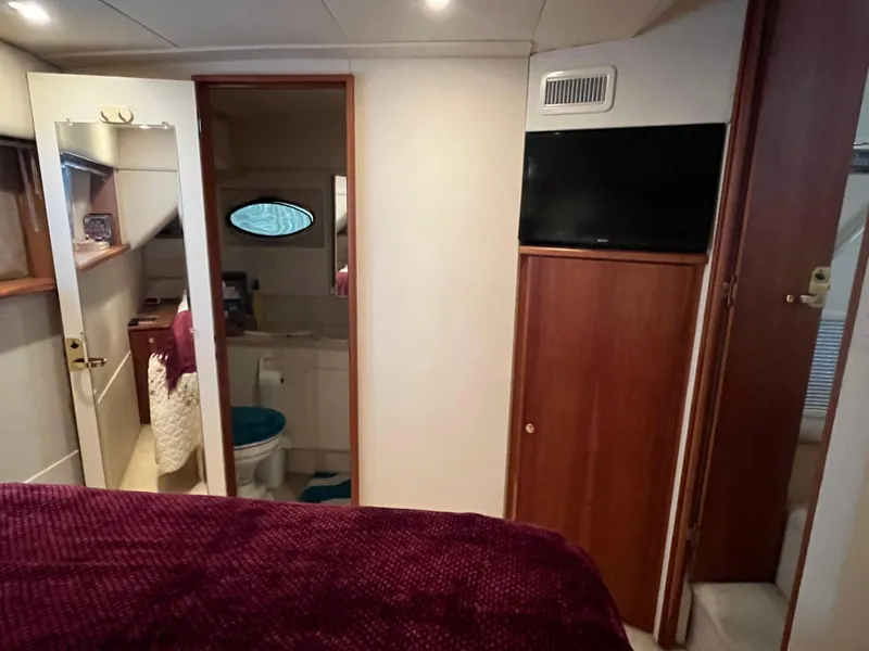 Slide: The Image of 1999 Silverton 392 Aft Cabin interior with cozy bedroom, bathroom, and TV. - 28